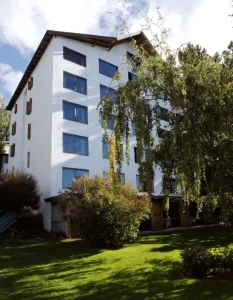 Aparthotel Costa Azul por fuera junto a un árbol