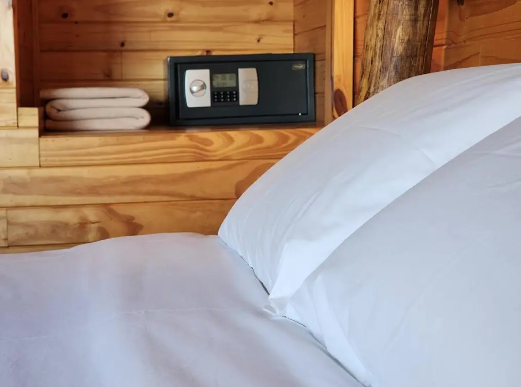 Cabañas Alechen cama doble junto a la caja fuerte