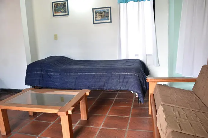 Cabañas Cinco Soles cama individual junto a la mesa